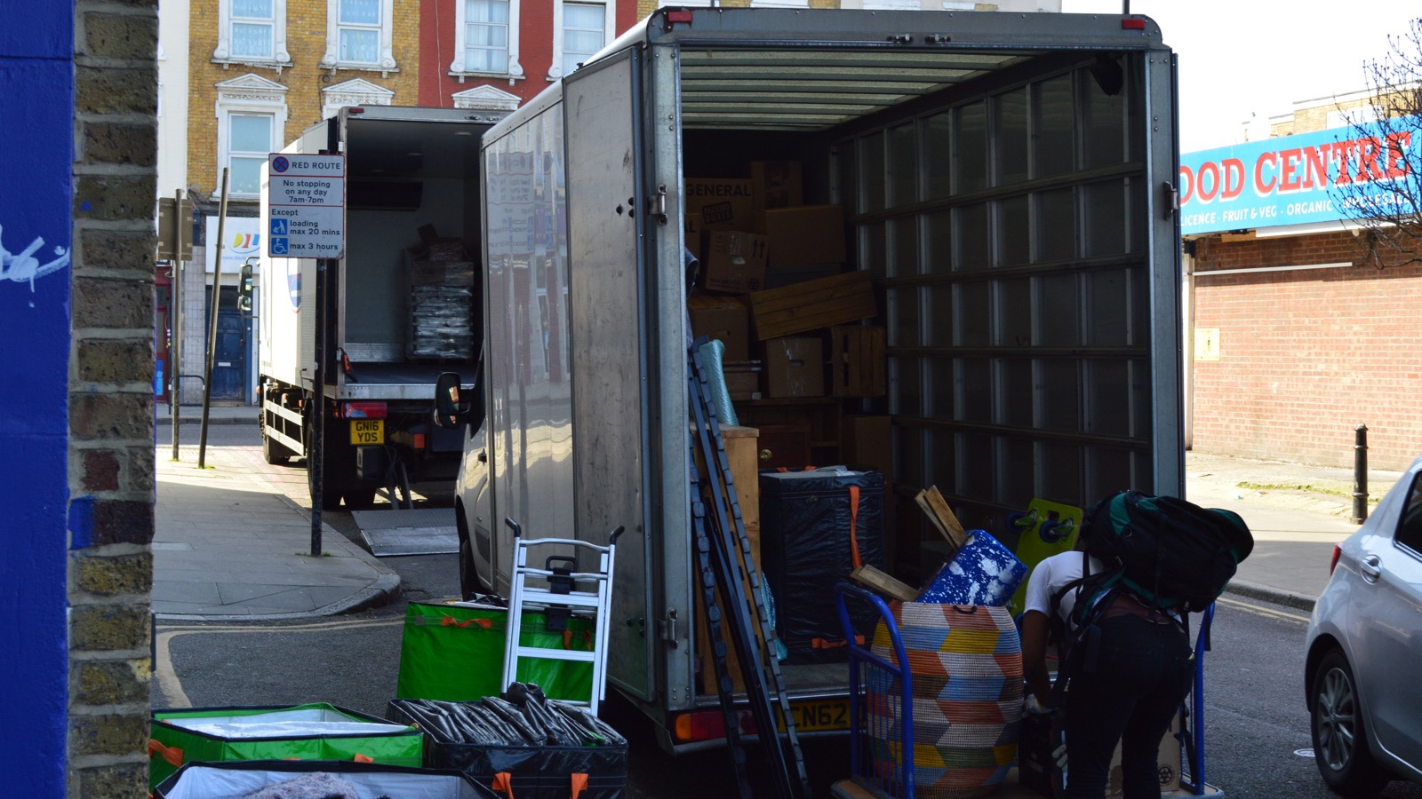 Two Men With Van Luton vans during loading near a visible London red route sign