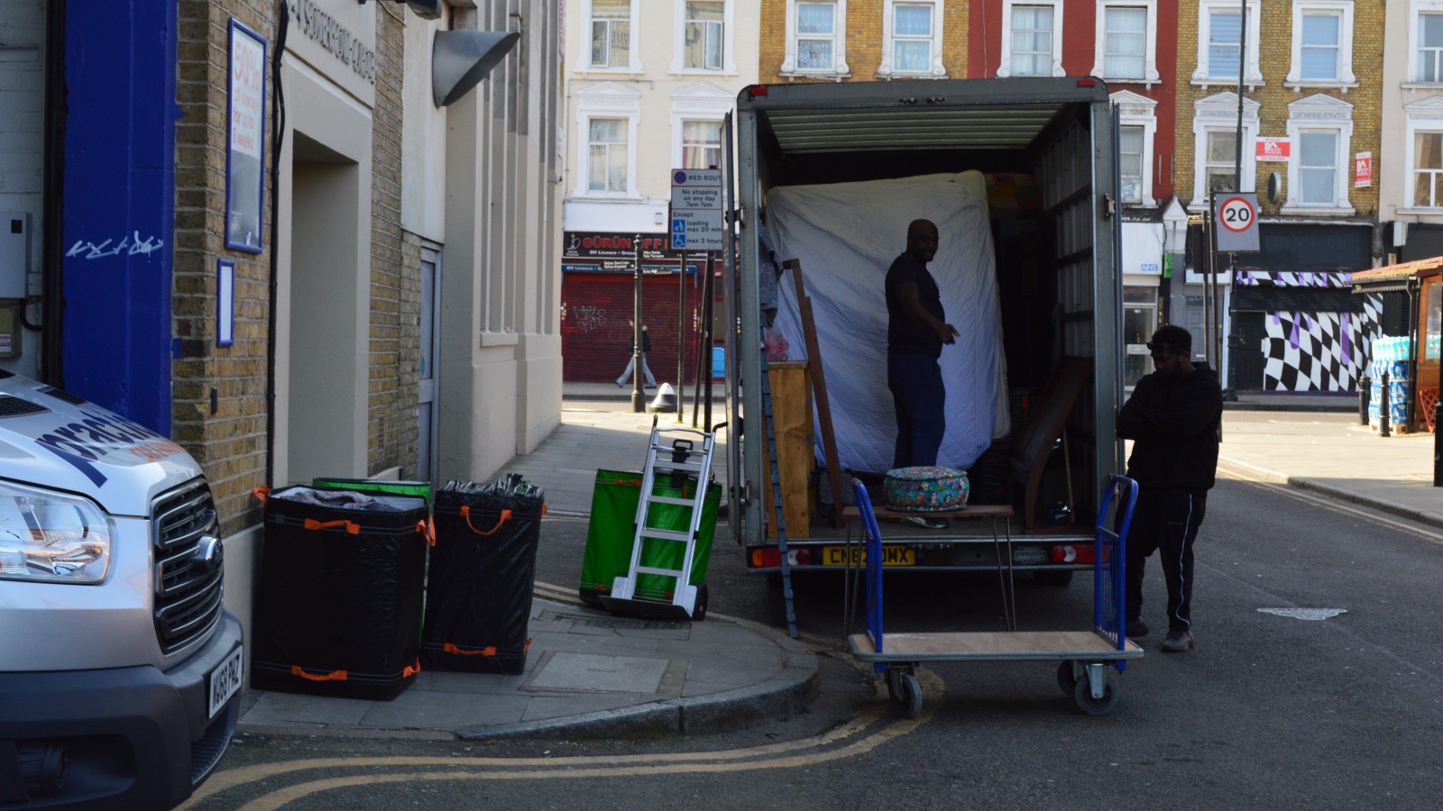 Men With Van removal team beside an open Luton van with furniture and moving equipment