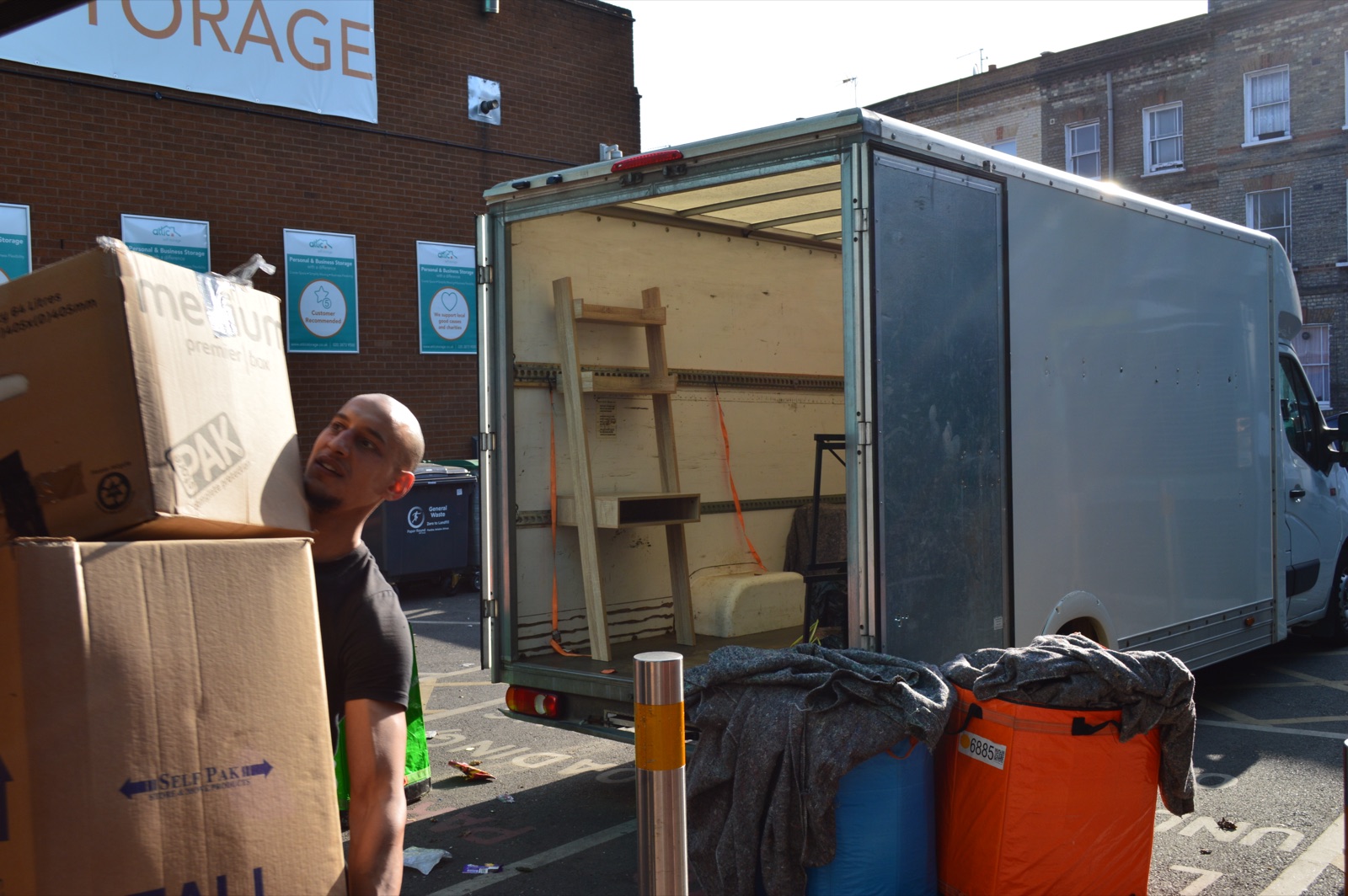 Mover carrying packed boxes outside during a removal