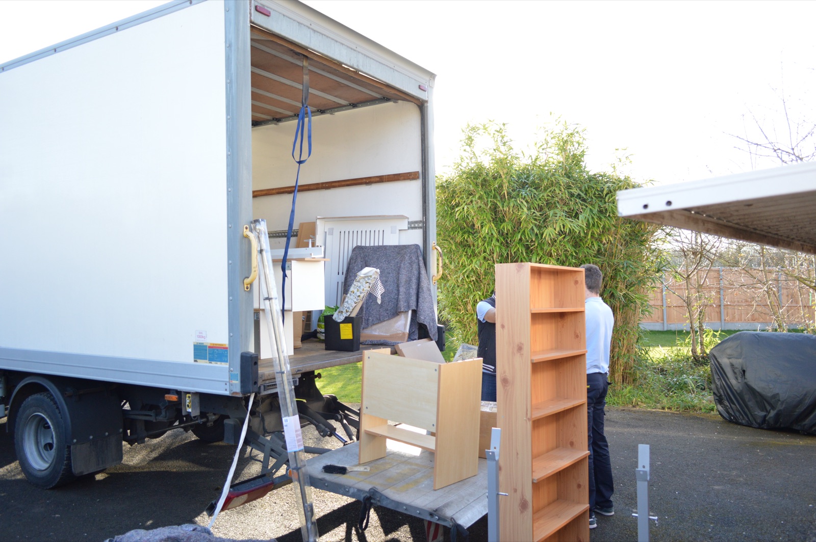 Furniture being moved from a garden area into a Luton van