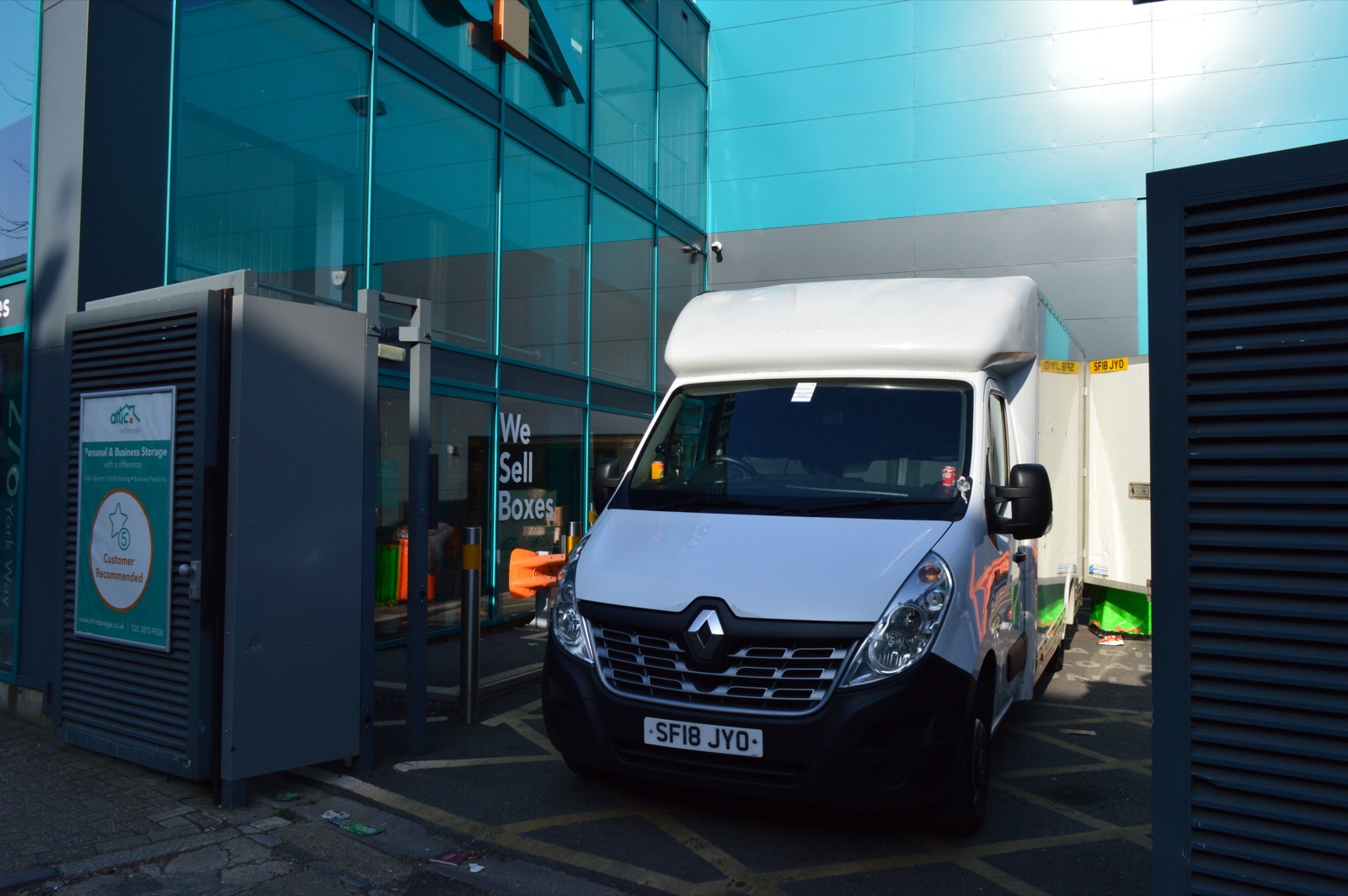 Unbranded Luton removal van positioned outside the entrance of a storage facility