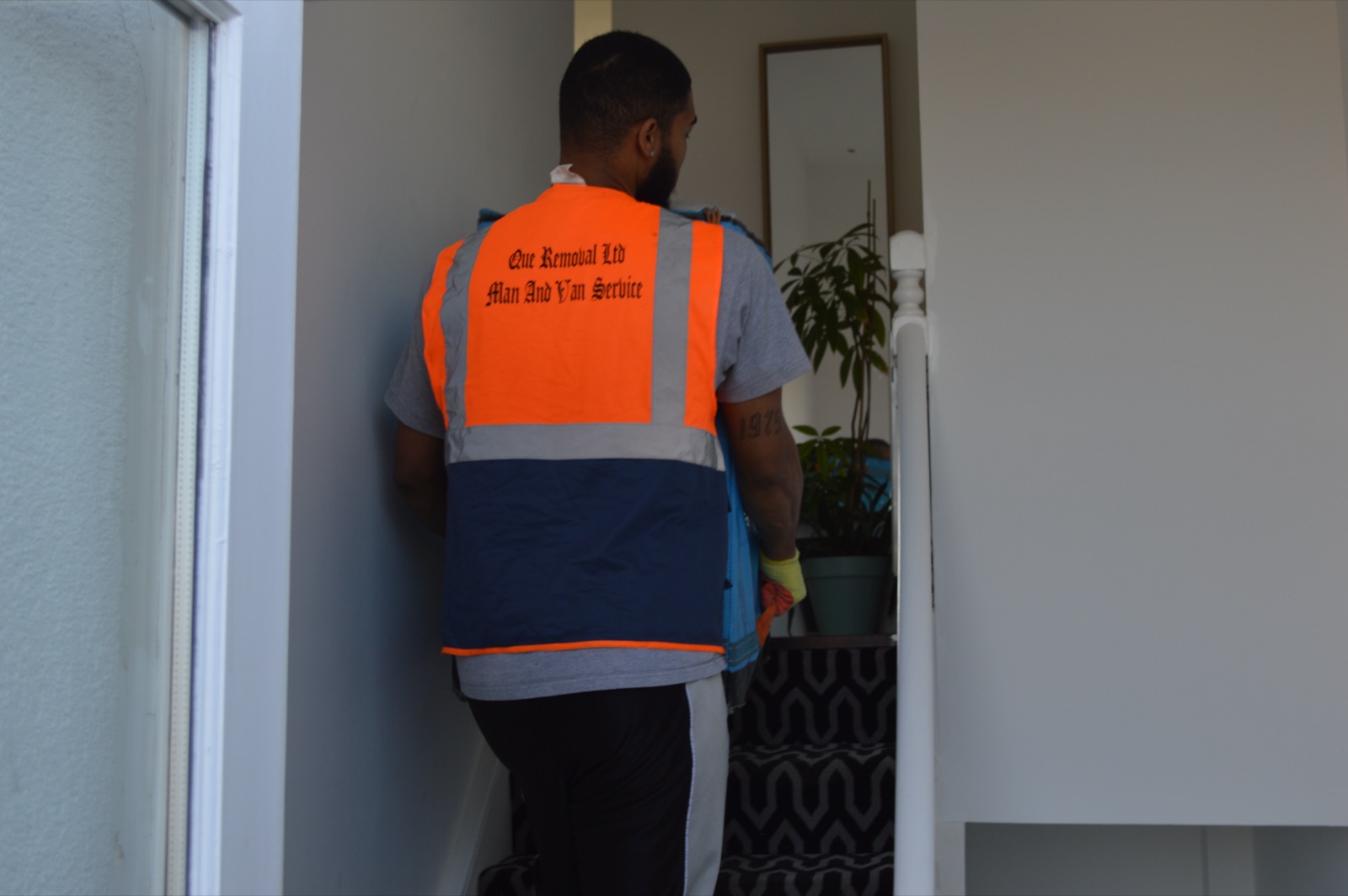 Mover carrying an item on stairs during a removal job